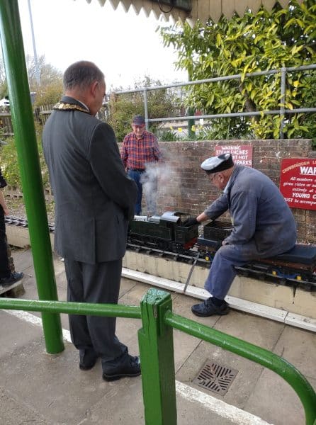 The mayor watches the miniature railway engine being started
